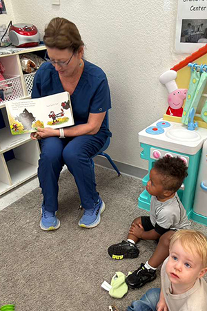 Teacher reading to toddlers at early literacy daycare Kerrville