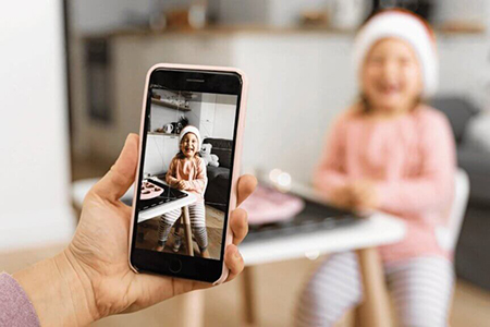 Parent using mobile app updates while choosing a daycare center like Live Oak Bright Beginnings Daycare and Preschool in San Antonio, Texas