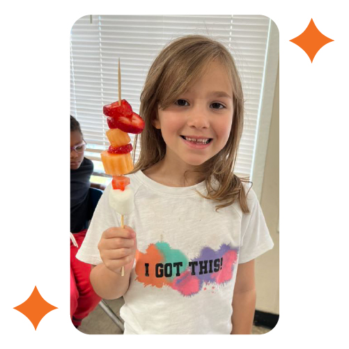 Child holding healthy fruit snack at Learning Center Live Oak after school program