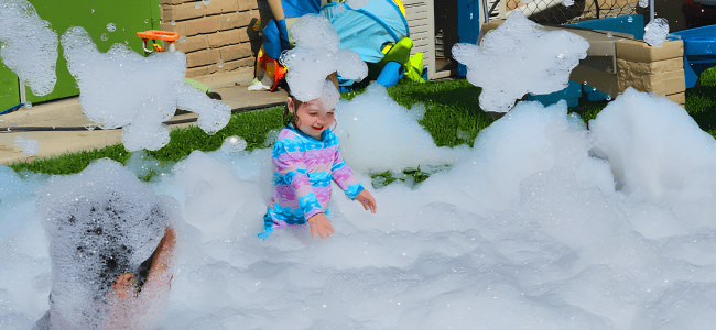 Children enjoying sensory play with bubbles at Live Oak BB Daycare promoting play in early childhood development